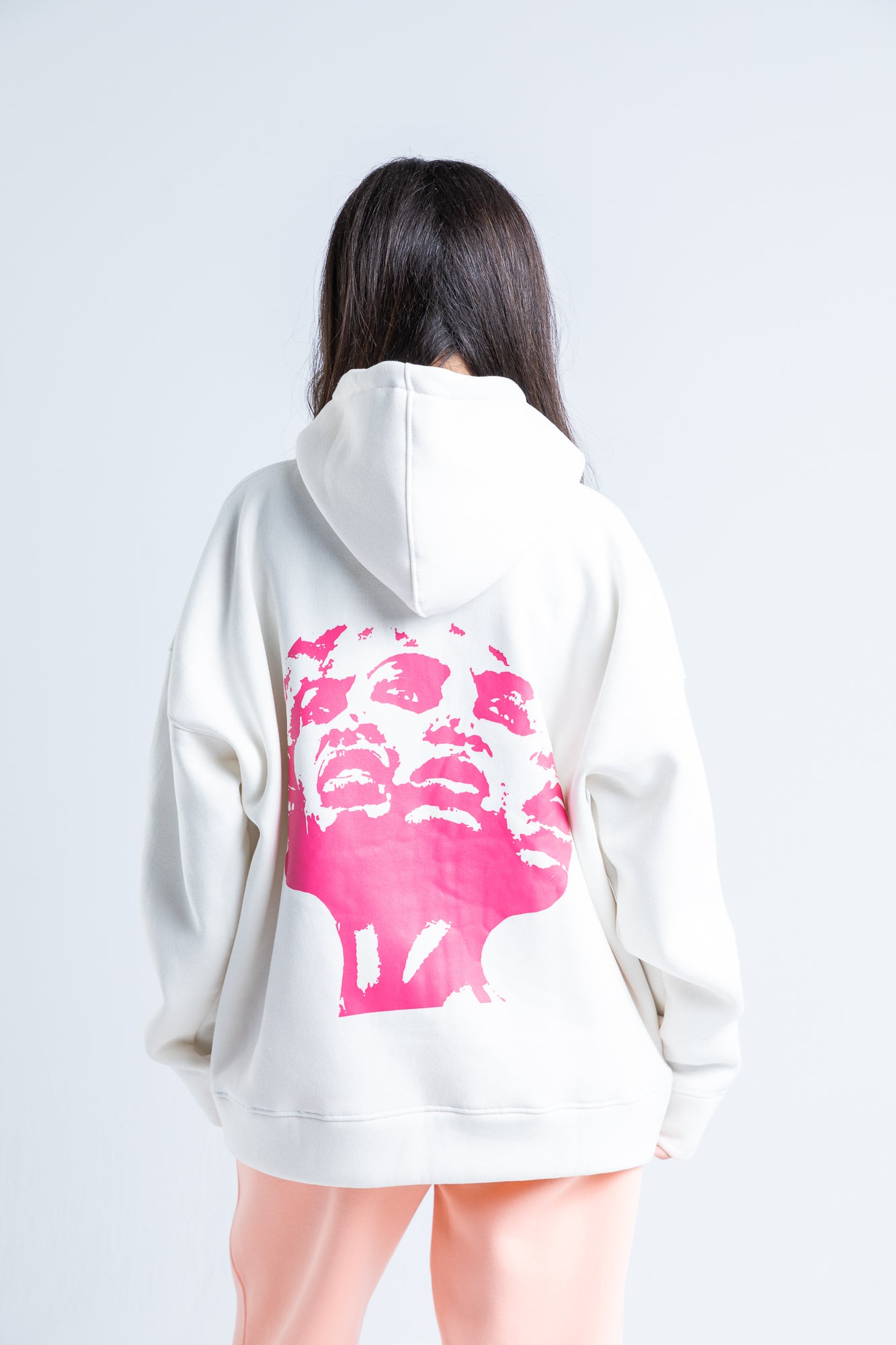 Back view of pink distortion hoodie showcasing a plain back with a comfortable, oversized fit and soft fabric