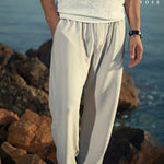 Close-up of men's white linen pants fabric showing the breathable texture and elastic waistband for a secure, comfortable fit.