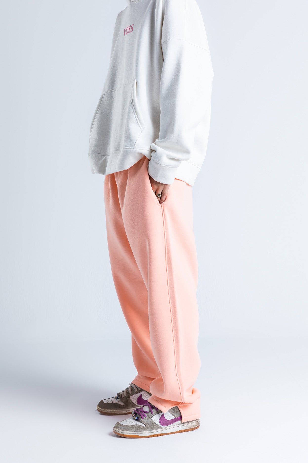 Side view of pink wide-legged sweatpants highlighting the wide-leg cut and flowing silhouette for everyday wear.