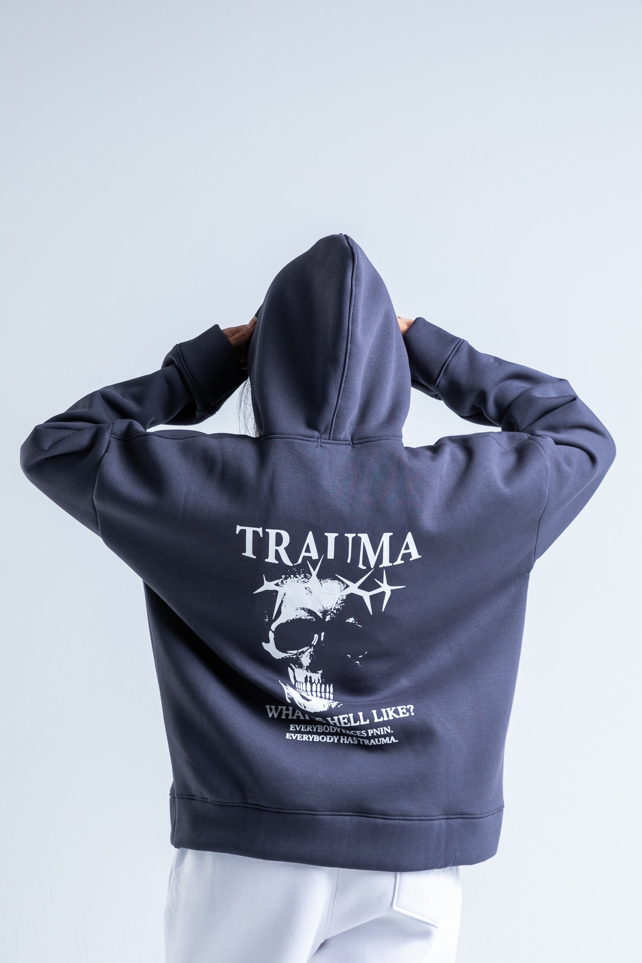 Back view of Trauma hoodie showcasing a plain back with a cozy, oversized fit and soft, durable fabric.